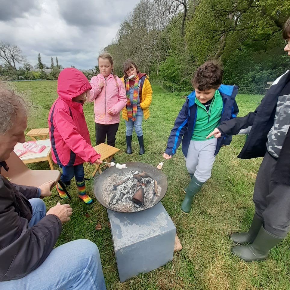 Photo of children toasting marshmallows on a fire