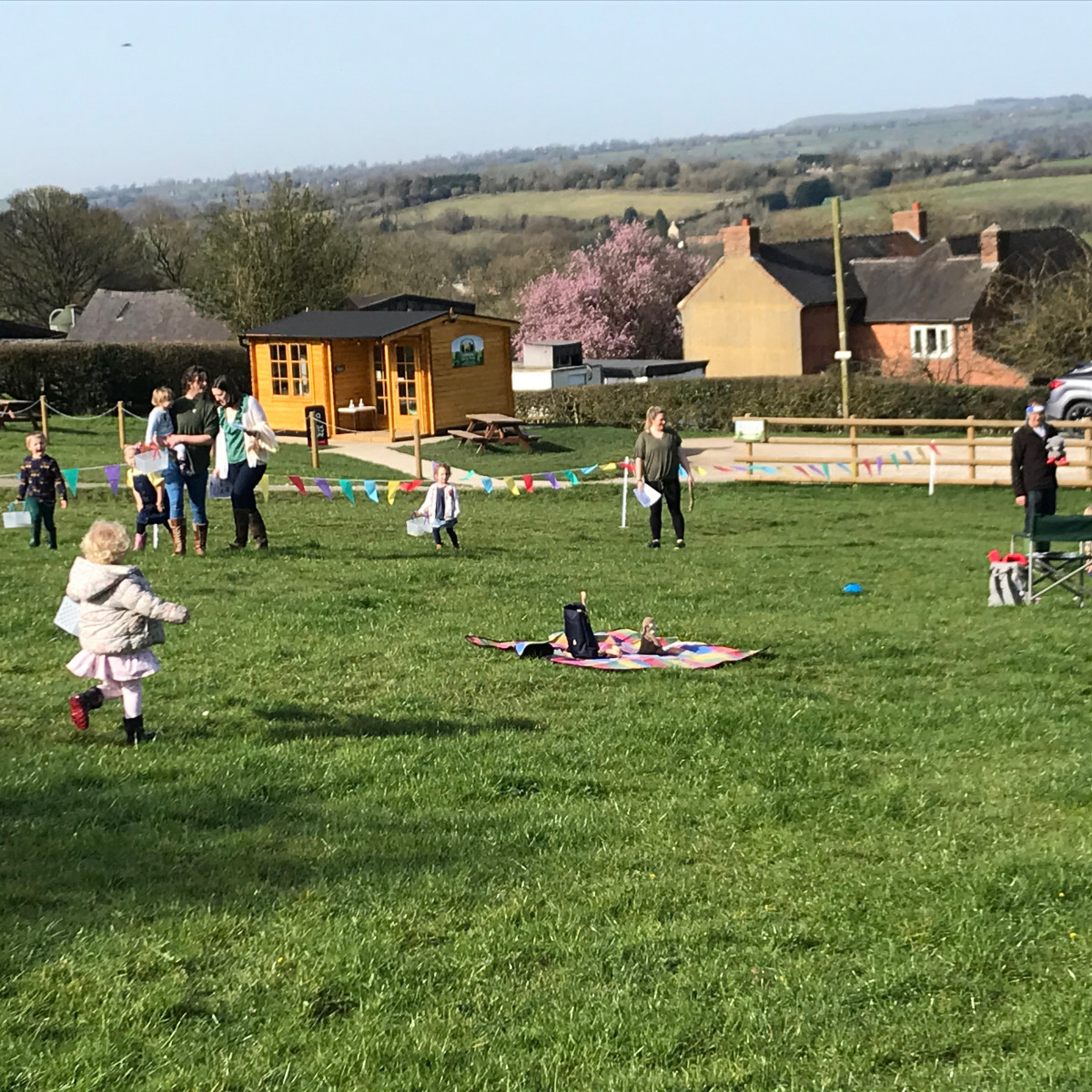 A photo of adults and toddlers in a field